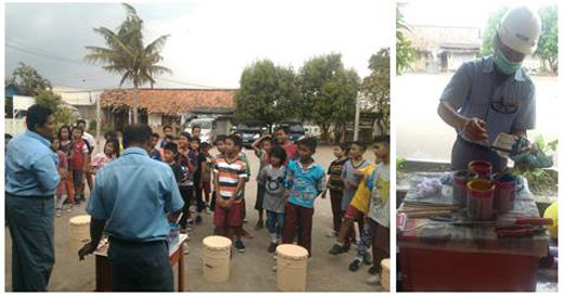 Employees explain the importance of properly disposing of garbage and help the children build wastebaskets