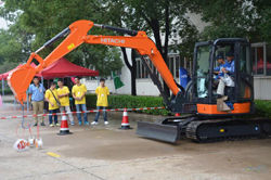 Visitors ride along in a compact excavator