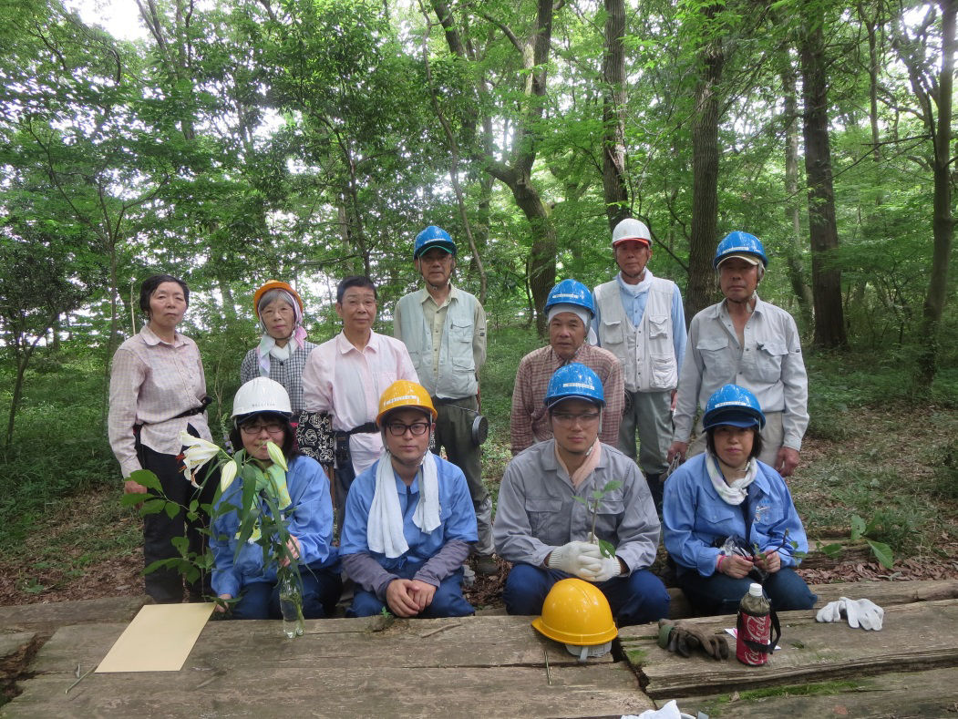 Group picture, upon completion of activities, with a brightly lit forest in the background