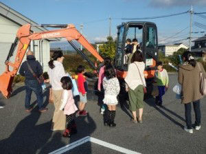 Families took pictures of their children taking their turn on the mini excavator
