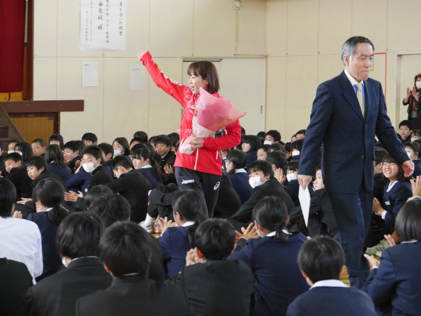 美園中の阿久津一浩校長（右）と、たくさんの拍手を受けながら退場する中山選手（左）