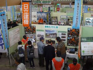 A staff member explains the company’s initiatives at the indoor booth