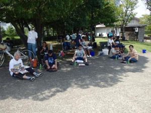 Watching the dragon boats while eating lunch boxes in the shade