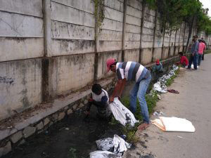 工場壁面の排水路を清掃