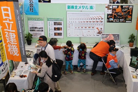 A staff member explains the company’s initiatives at the indoor booth