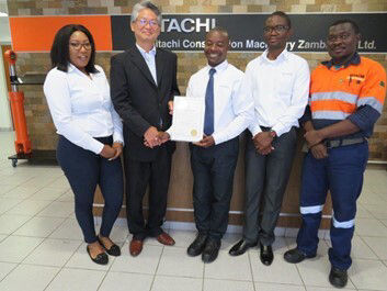 Members of Platinum Award-winning Team with Hideki Hattori, HCMZ President (2nd from left) (*This photo was taken at the Zambia Kaizen Conference held prior to the International Convention on QC Circles. Masks were momentarily removed for the photo.)