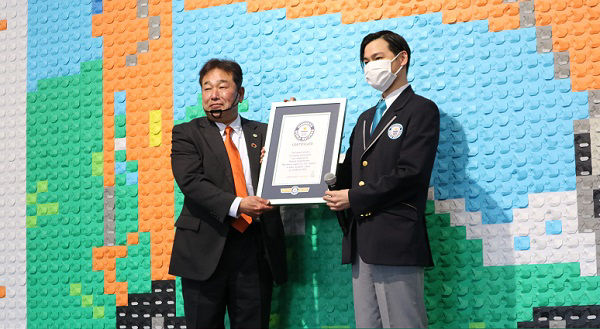 ギネス世界記録™の公式認定員から公式認定証を受け取る日立建機日本 榎本一雄取締役社長（左）