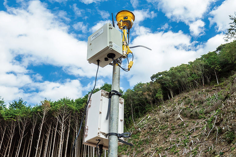 GNSS基準局のアンテナから、ICT建機の受信機に位置情報や施工設計データが送られる。