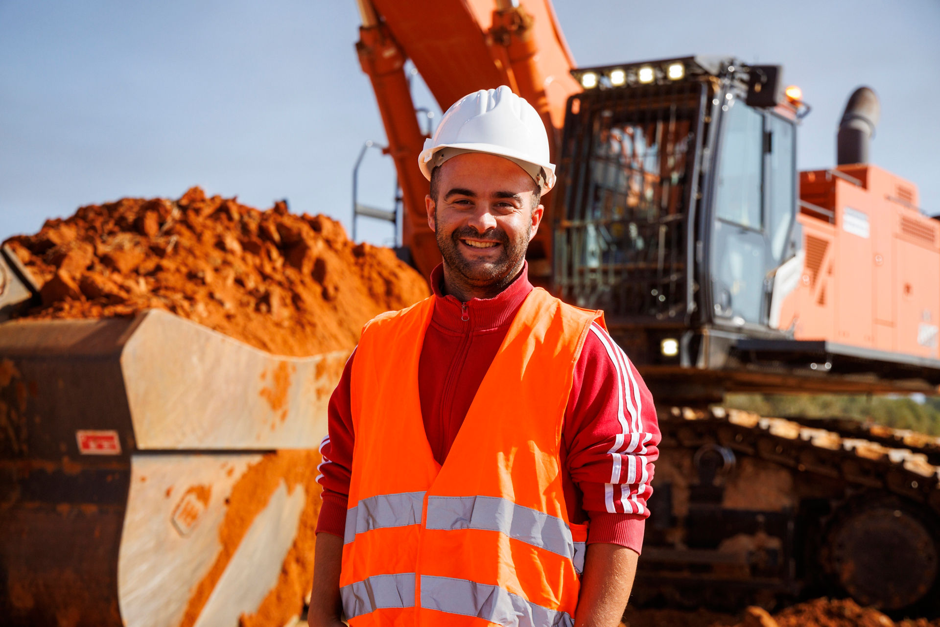 smiling operator of a Hitachi large excavator in Greece