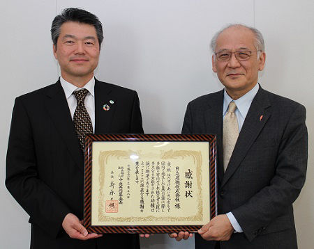 先崎正文執行役（左）と、中央共同募金会の渋谷篤男常務理事（右）