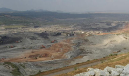 At the huge open-pit mine, Hitachi shovels and dump trucks are working.