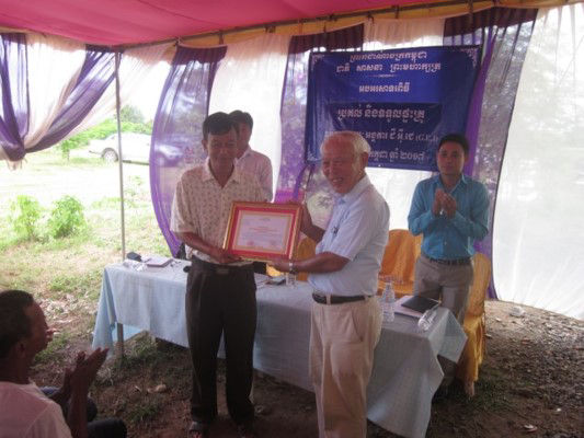 Director of Bavel district Education Bureau (left) presents Makoto Teradaira, director of GEJ, with a letter of appreciation