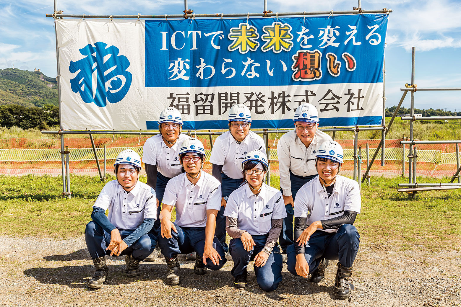 ICT活用工事を示す横断幕の前で、現場担当の皆さんが集合。