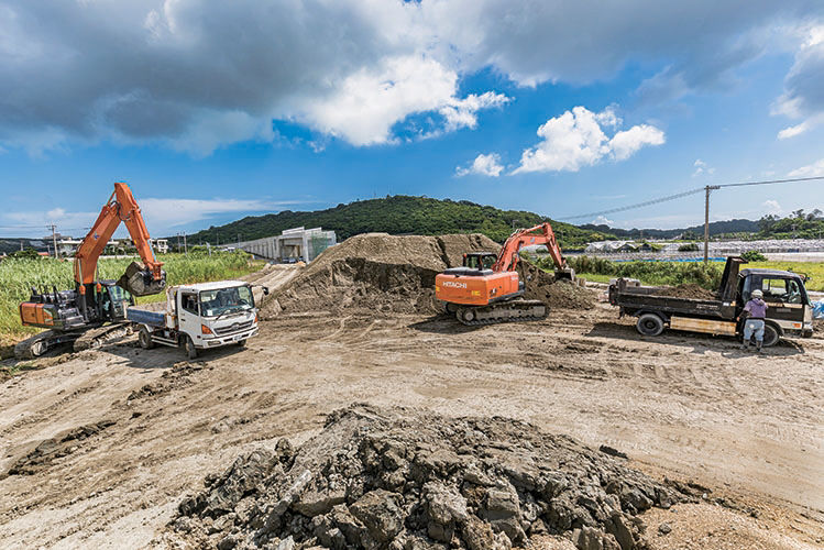 現場風景。中央に盛られた土はほかの工区の残土が仮置きされたもの。土質改良後に当地の盛土にも使われる。